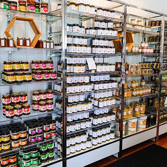 3 floor-ceiling glass racks filled with small jars.