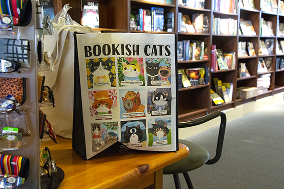 A black and white tote bag with 9 cartoon cats