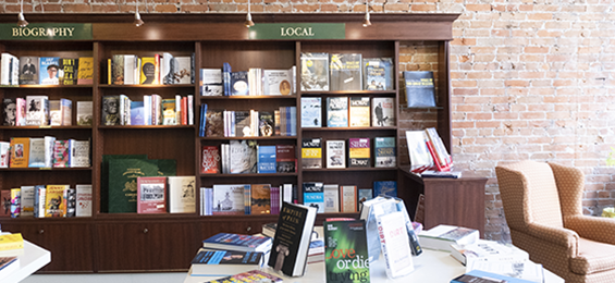 Large brown bookcase on a brickwall.