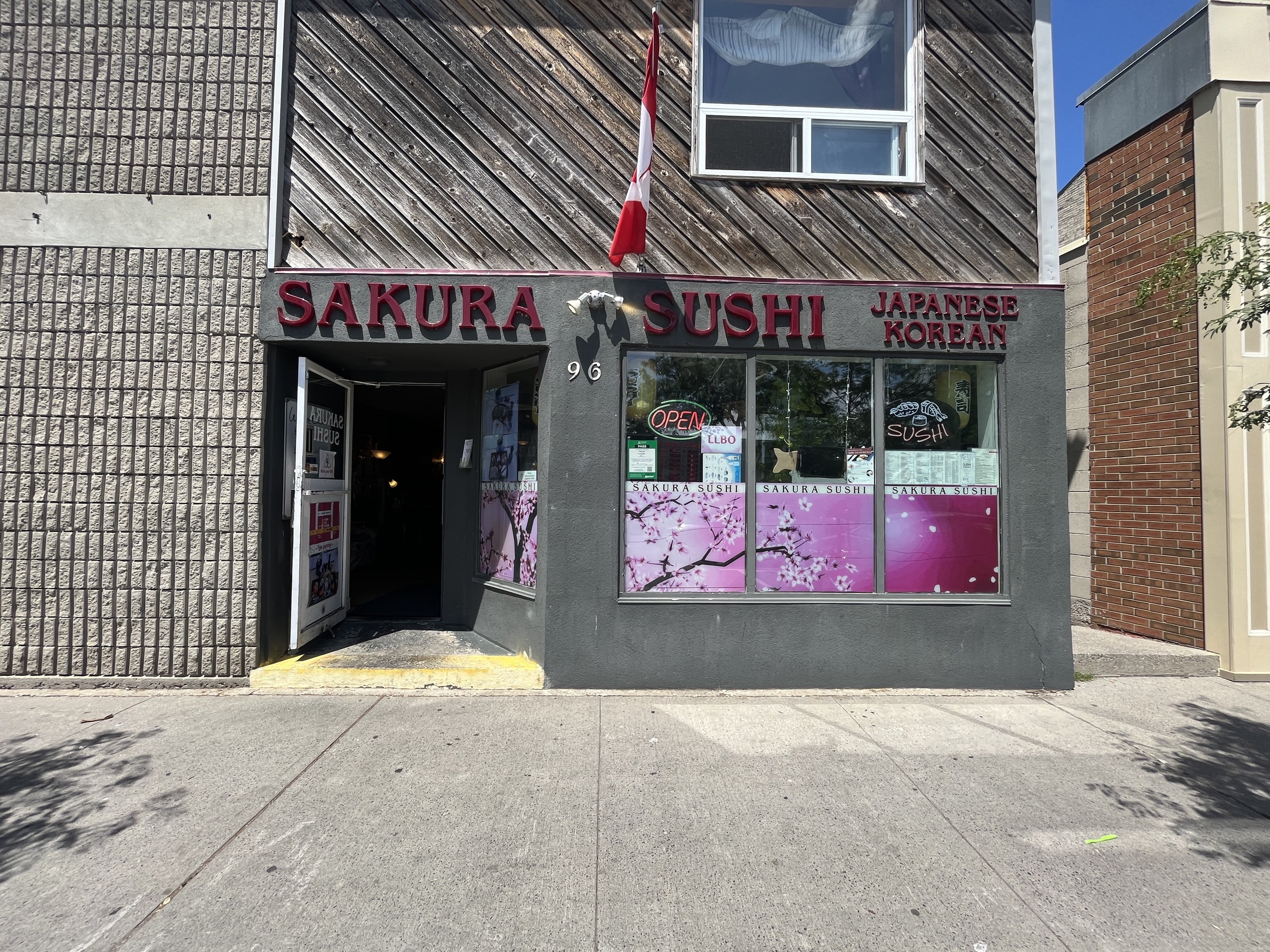 Photo of Sakura Shusha store front. Sign above door entrance reads "Sakura Sushi Japanese Korean."