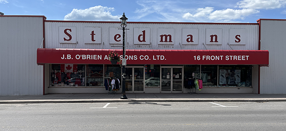 White building with red framing and large red letters above a red awning.