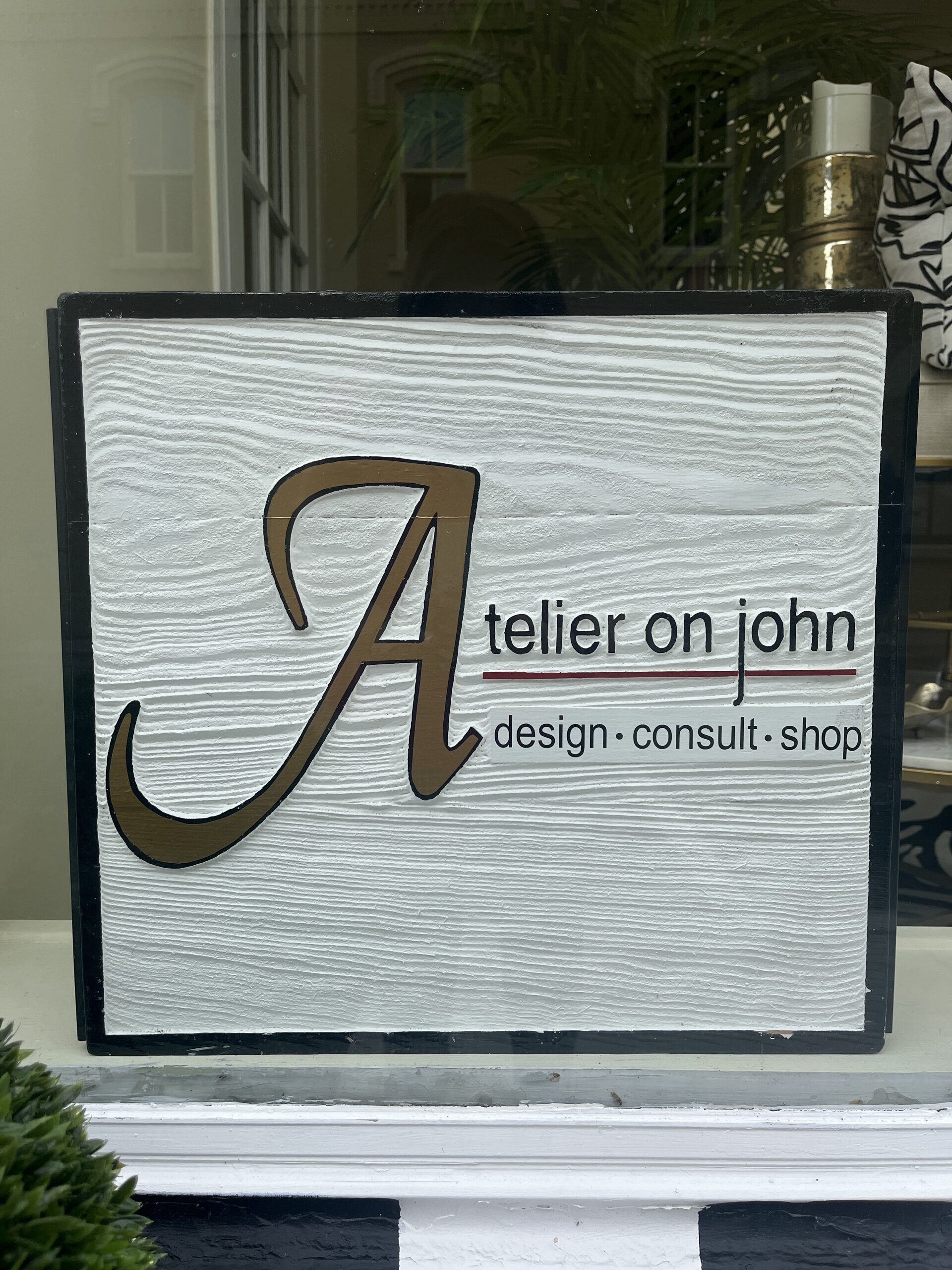 Photo of Atelier on John sign. Sign reads "Atelier on John. Design, consult, shop."