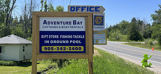 White and blue sign framed with wood pillars.