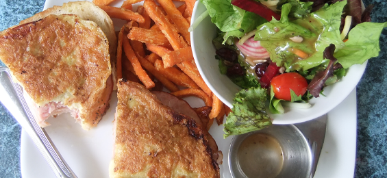 Plate of food; sandwhich, sweet potato fries and garden salad.