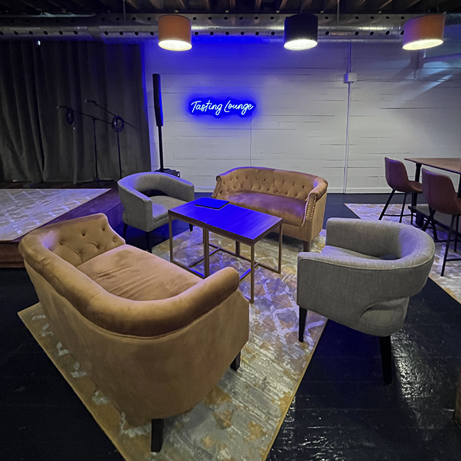 Couch lounging area with a blue LED Tasting Lounge sign