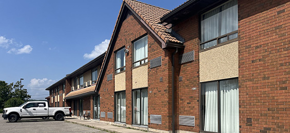 Long brick hotel building with lots of patio doors.