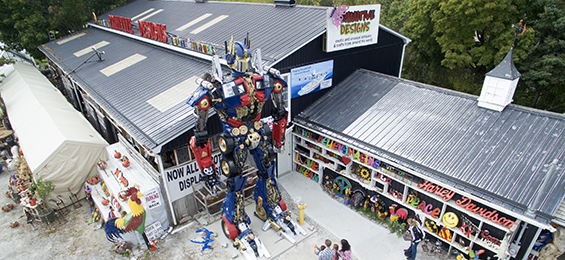 Large black barn-like building with a large metal sculpture in front.