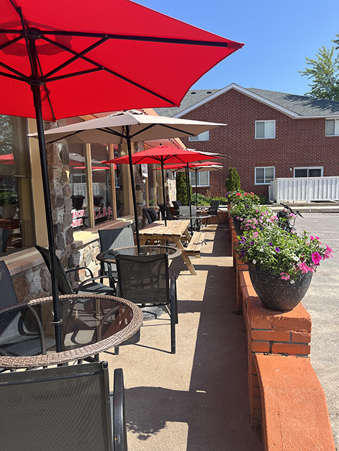 tables and chairs with umbrellas on a patio.