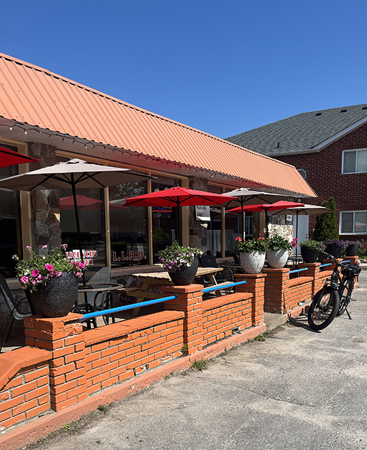 Tables and chairs with umbrellas on a patio.