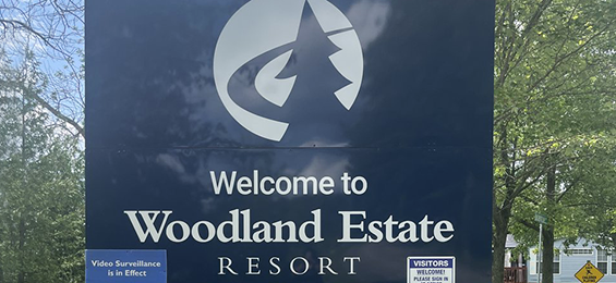 Navy blue sign with white writing and logo.