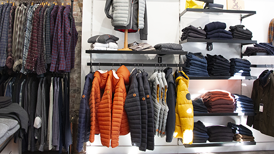 Mens clothing displayed on racks and shelves.