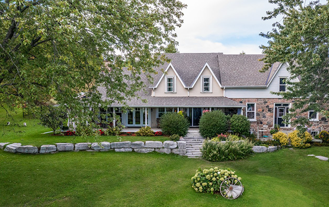 Large house with flower beds in front.