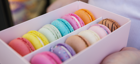 12 colourful macaroons in a white box.