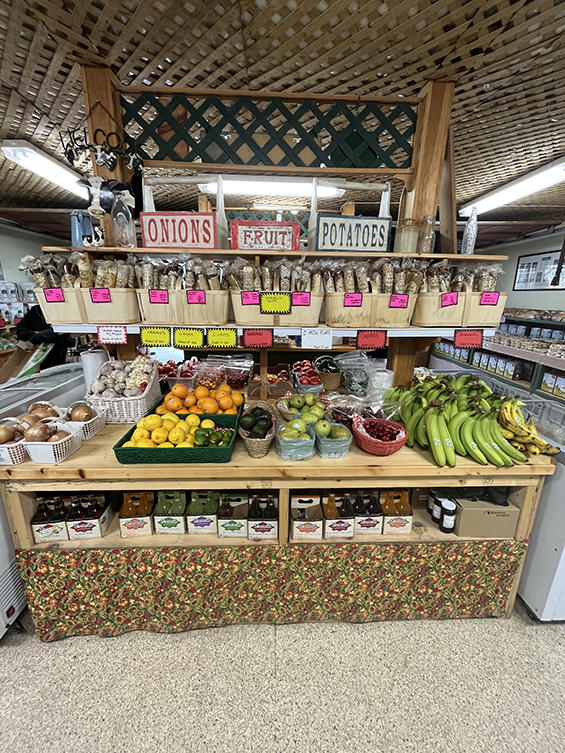 Fruits, vegetables and soup kits displayed on a wooden stand.