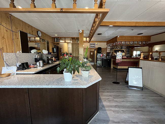 Brown and white counter looking into restaurant.