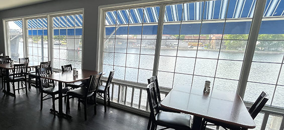 Tables and chairs set up along a window overlooking Campbellford canal.