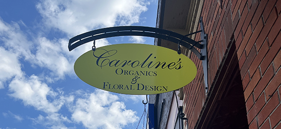 Yellow sign with fancy black writing.
