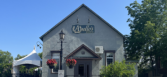 Green building with a patio on the side and a large sign.