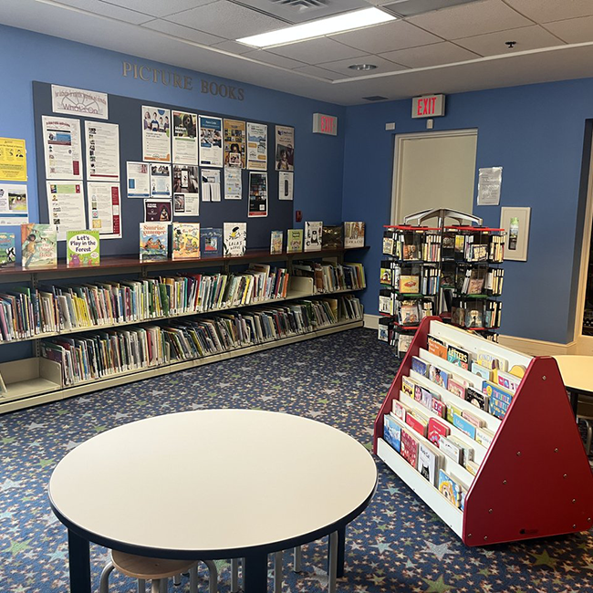 Small tables surrounded by shelves filled with books.