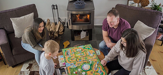 4 people sitting around a small table playing a board game.