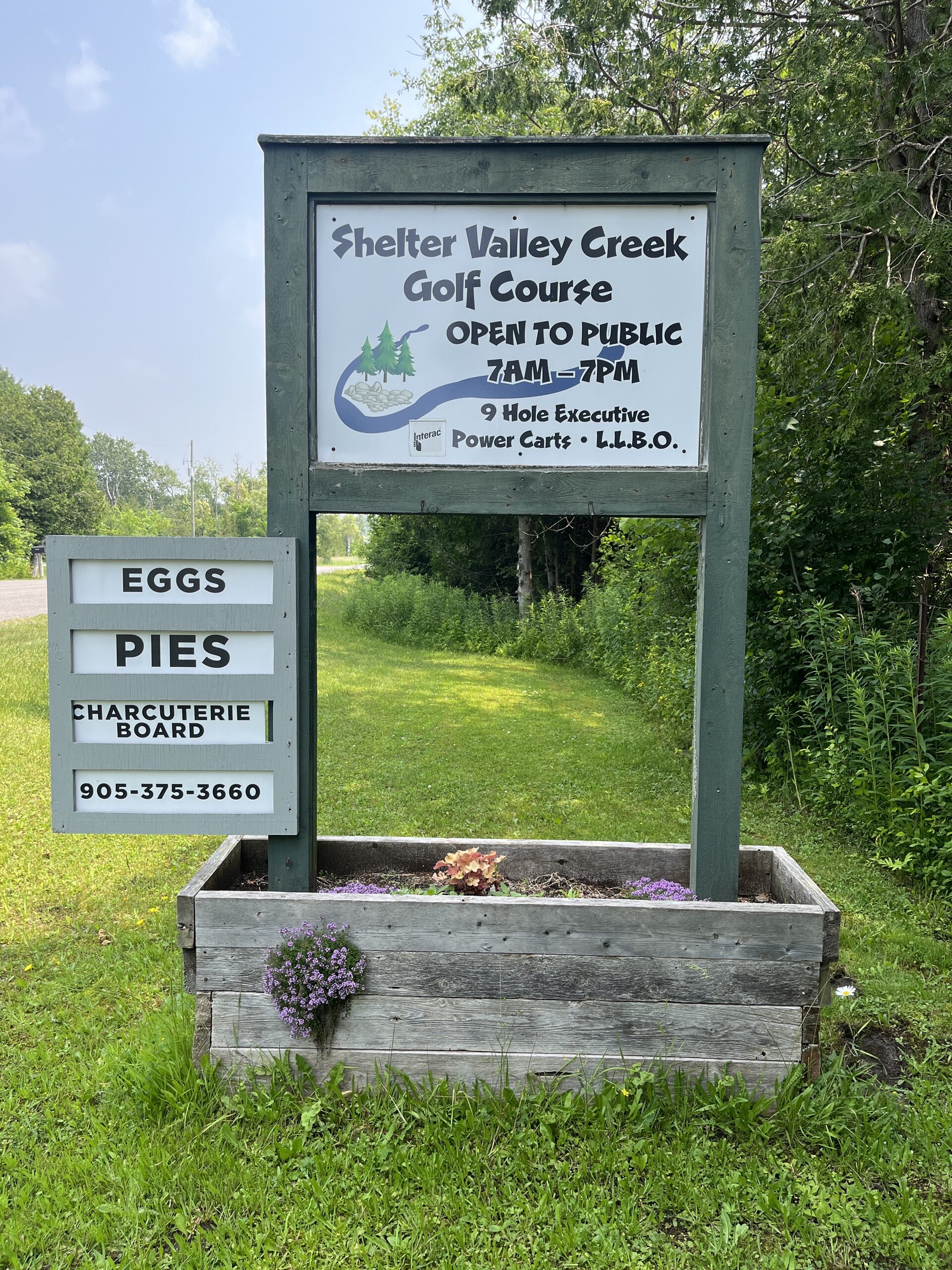 Photo of Shelter Valley Creek Golf Course sign. Sign reads "Shelter Valley Creek Golf Course. Open to public. 7am to 7pm. 9 hole executive. power carts."