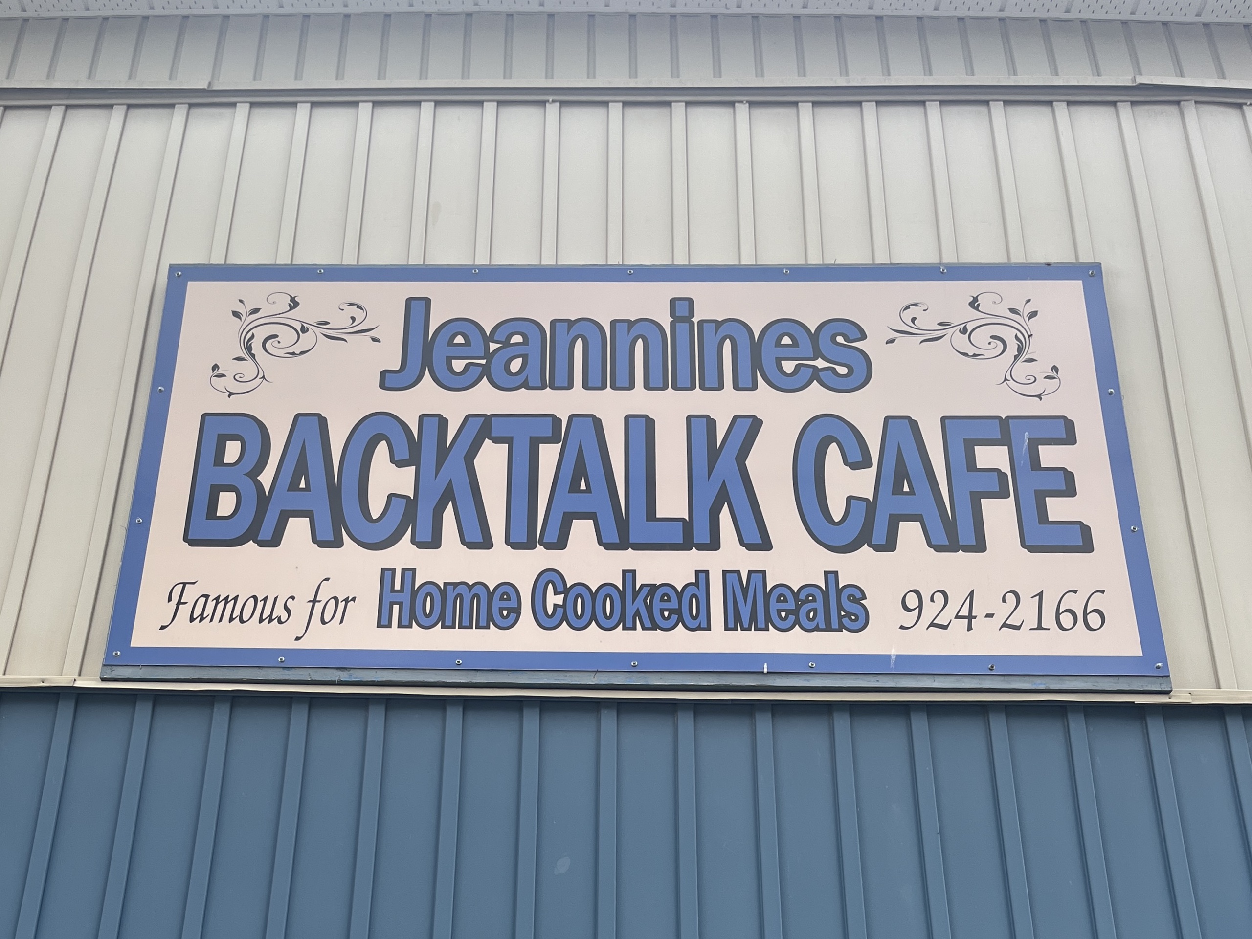 Photo of Jeanine's Backtalk Cafe sign. Sign reads "Jeannines Backtalk Cafe. Famous for home cooked meals. 924-2166."
