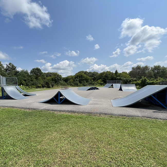 Skatepark ramps set up on pavement.