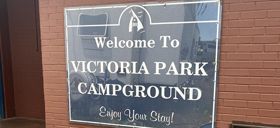 Navy blue sign with white writing and town of Cobourg logo.