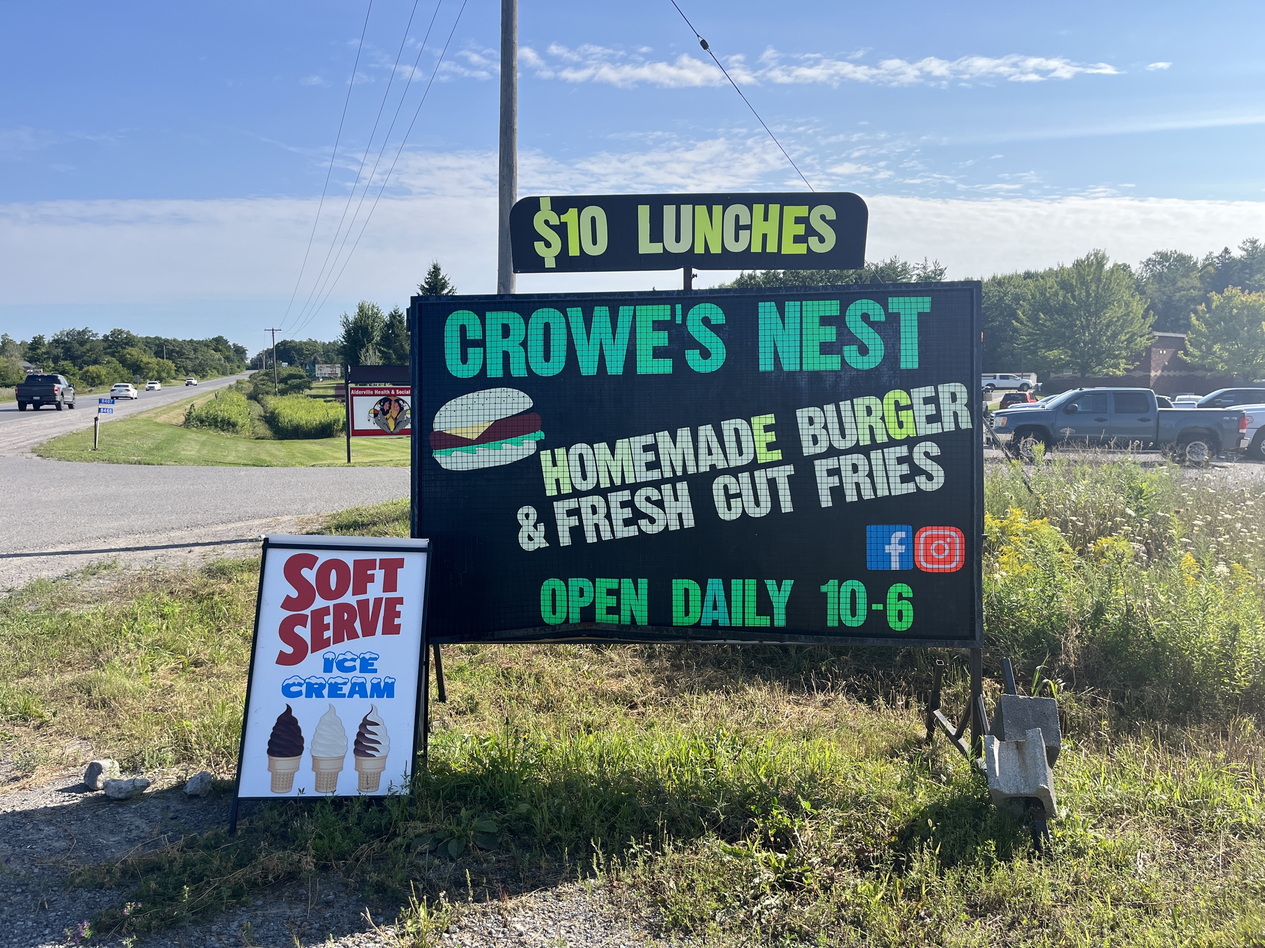 Photo of Crowe's Nest featuring a road side sign. Sign reads "$10 Lunces. Crowe's Nest. Homemade Burger & Fresh Cut Fries. Open daily 10-6."