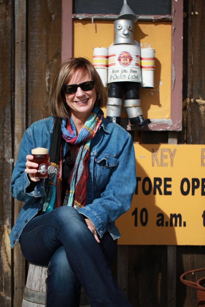 Woman holding a craft beer outside of Church Key Brewing