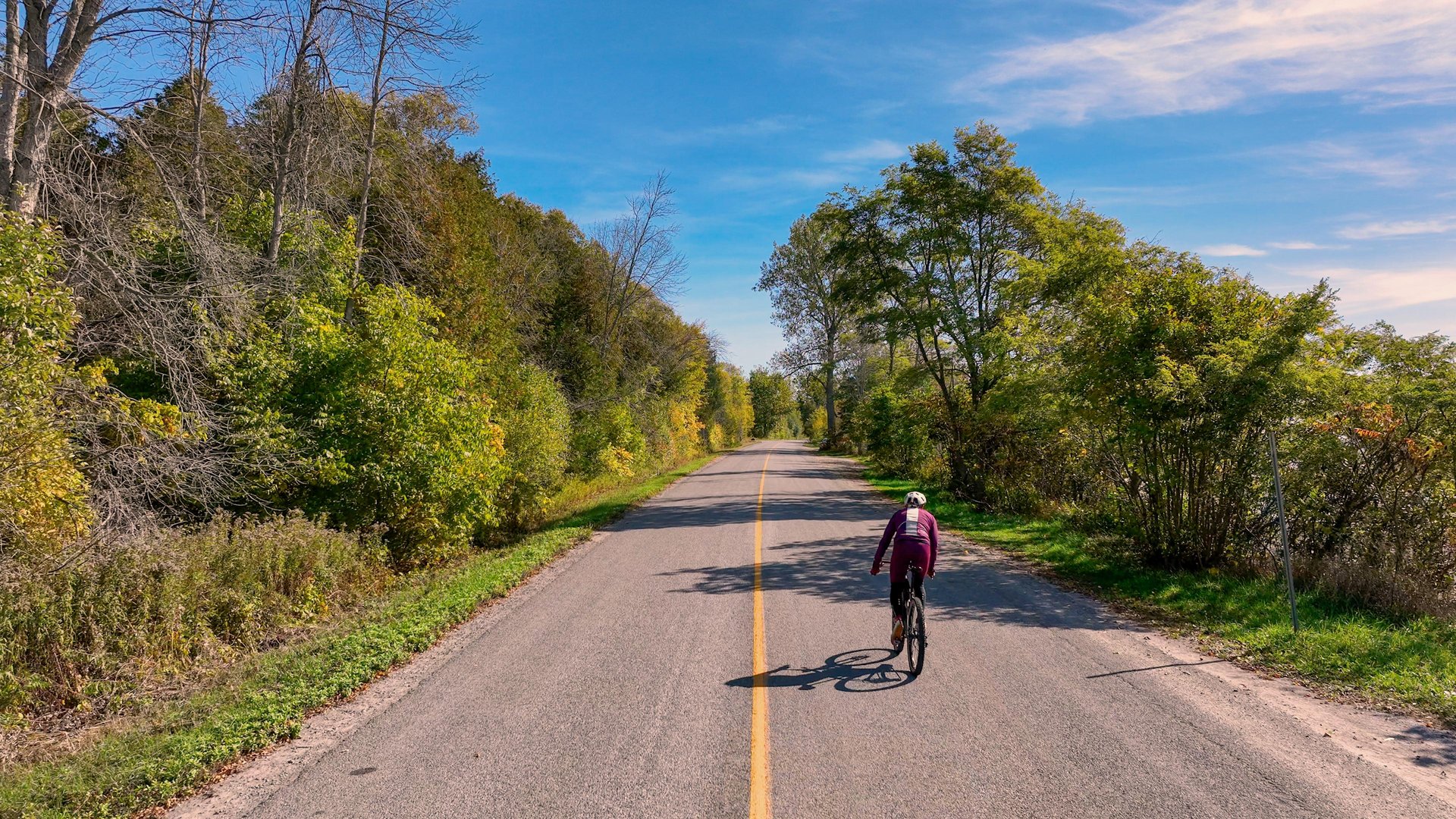 Man riding a bike along a country road