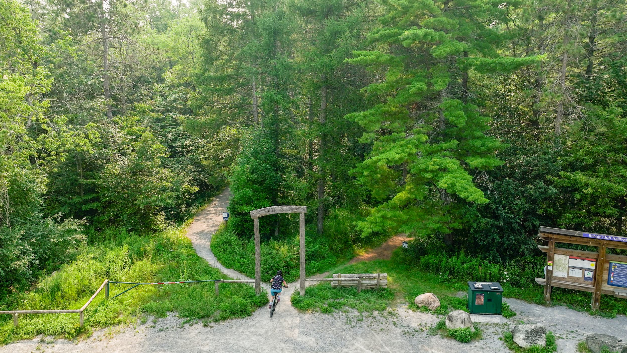 Drone view of a cyclist riding a mountain bike near a trailhead