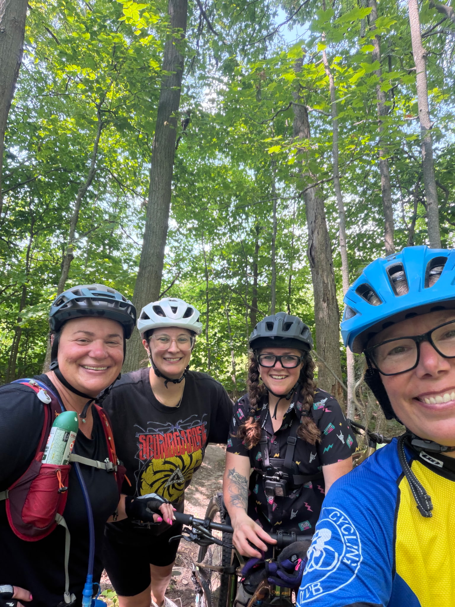 selfie of 4 women on bikes wearing bike helmets