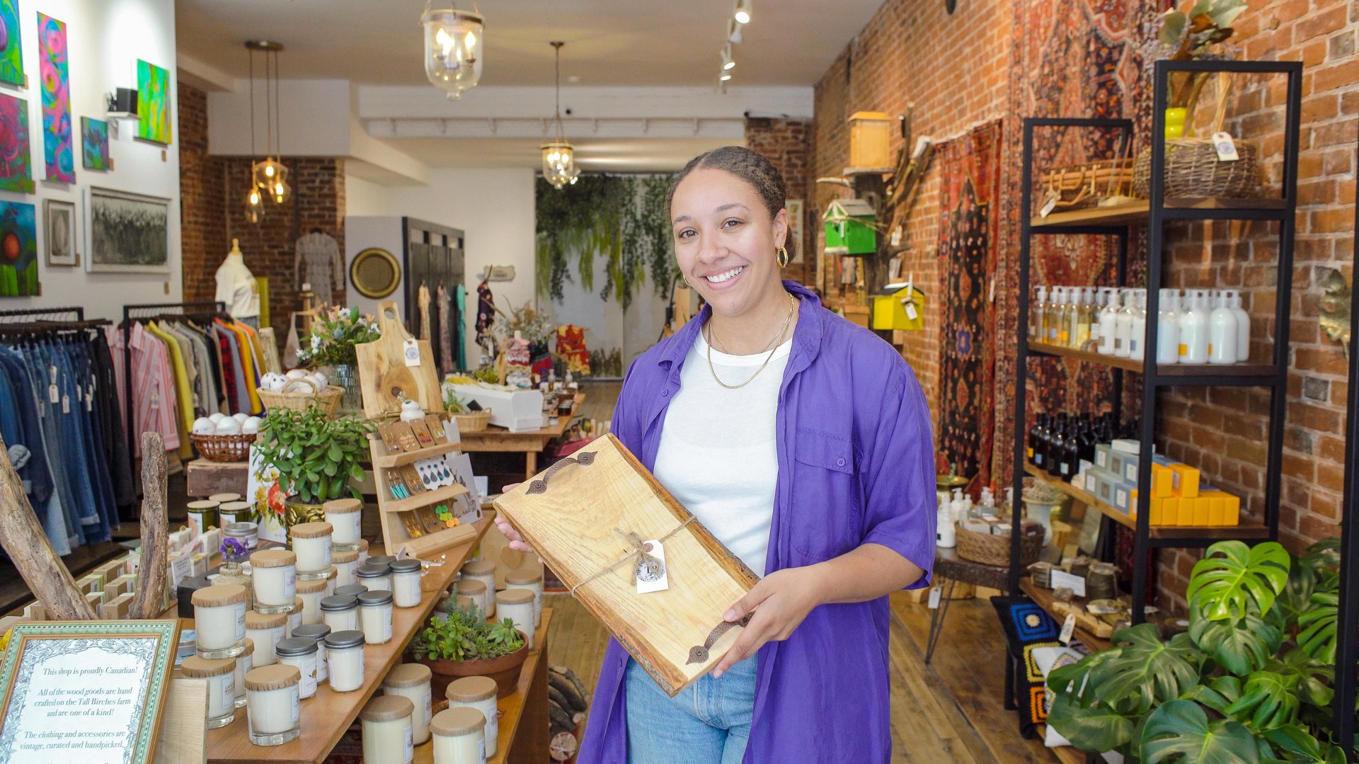 Female shop owner holding a wooden charcuterie board