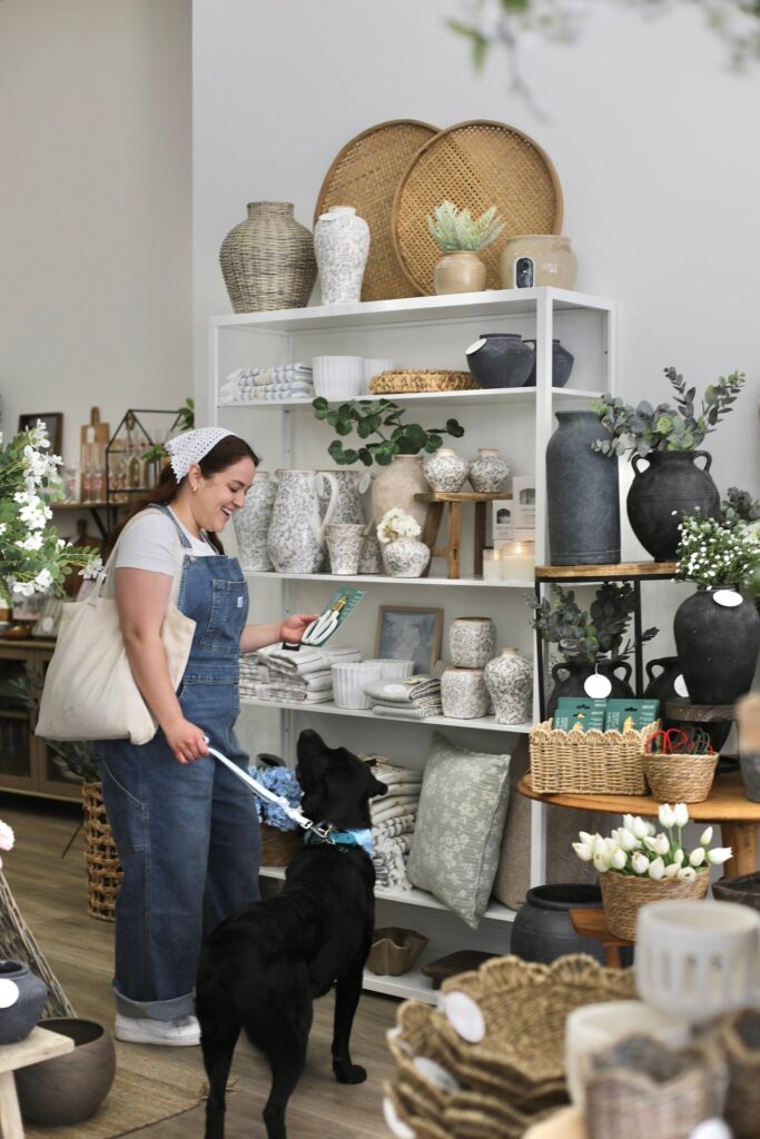 Woman shopping with her black lab in a home decor shop