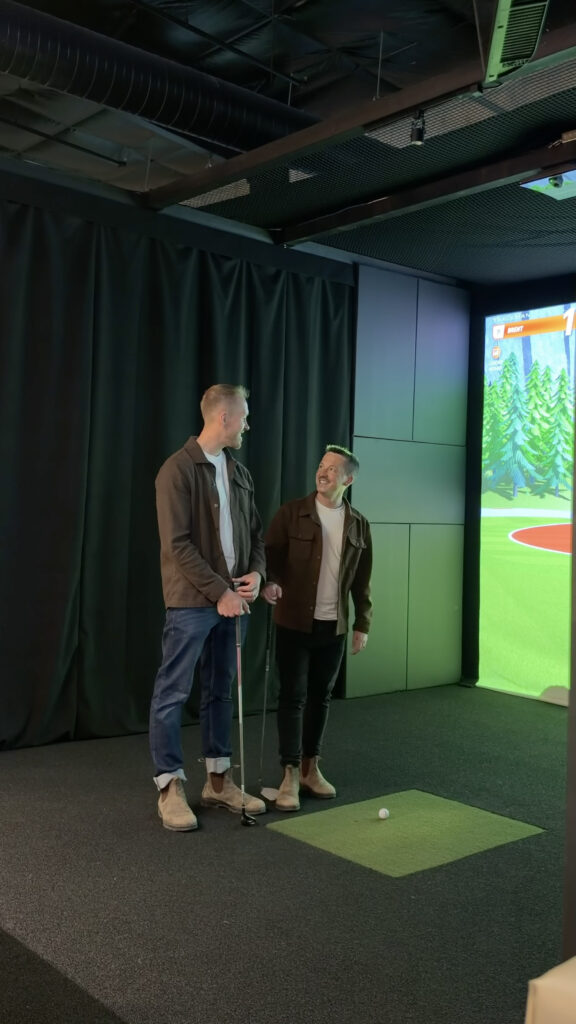 2 men using a golf simulator