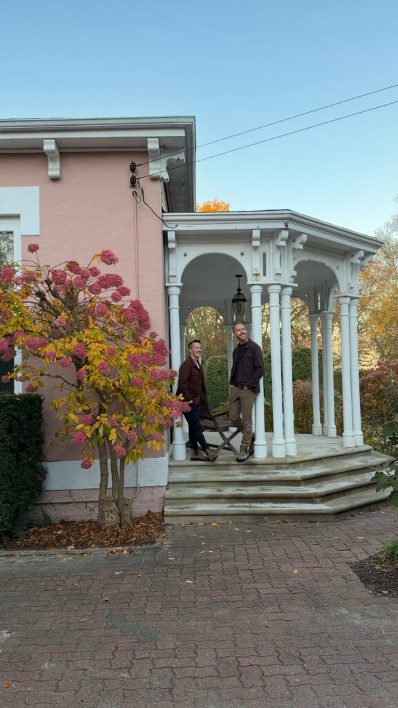 2 men standing on porch of Italianate style bed and breakfast